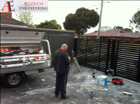 Black motorized steel gate made and installed by Allouch Engineering in Victoria